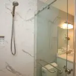 A bathroom with a shower, toilet and sink.