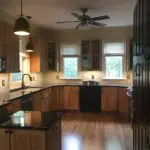 A kitchen with wooden cabinets and black counter tops.