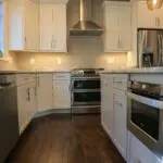 A kitchen with white cabinets and stainless steel appliances.