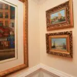 Two paintings are hanging on the wall next to a painting.