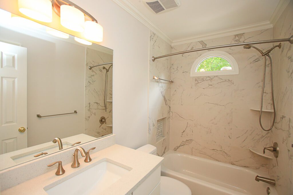 A White Color Bathroom With Brass Fittings One